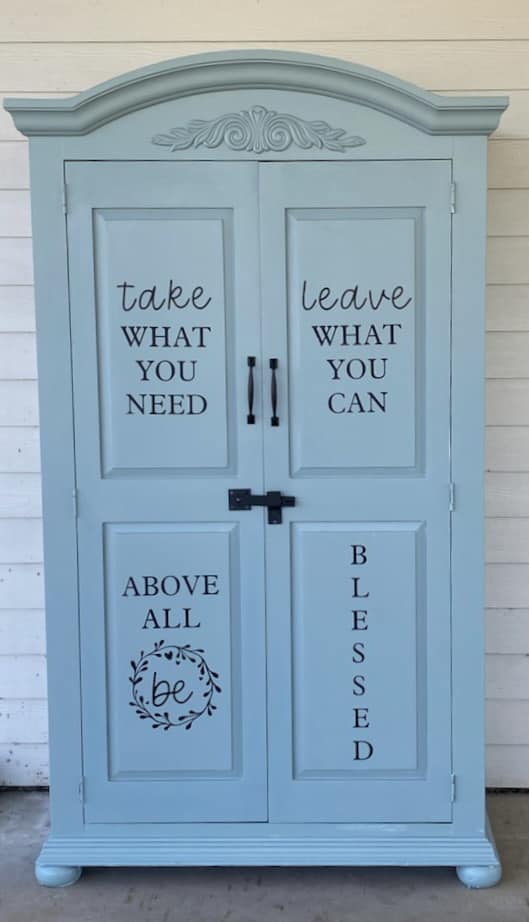 Free Pantry armoire with 'Take what you need, bring what you can' painted on the doors